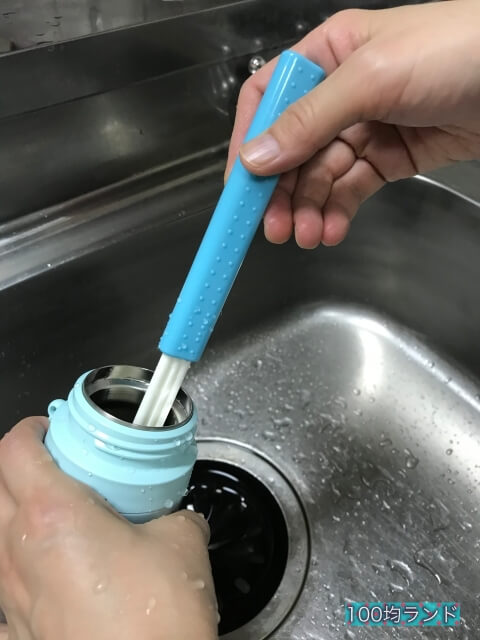 ダイソーのキッチン用品「コップボトル洗い（2段階伸縮タイプ）」で水筒の底を洗っている