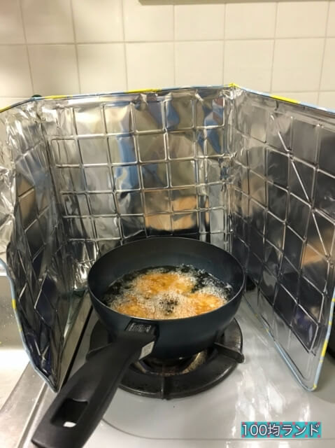 ダイソーのキッチン用品「ガスレンジガード（ワンコンロ用）」をコンロに設置し、揚げ物をしている